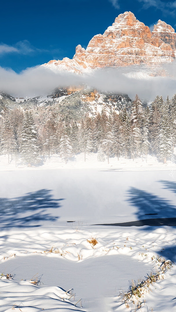 Zasypane śniegiem jezioro Antorno Lake i góry Dolomity