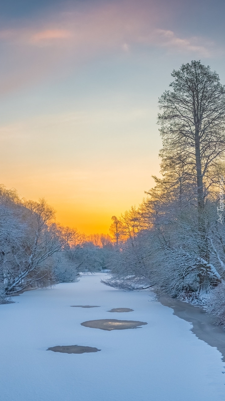 Zimowy wchód słońca nad zamarzniętą rzeką