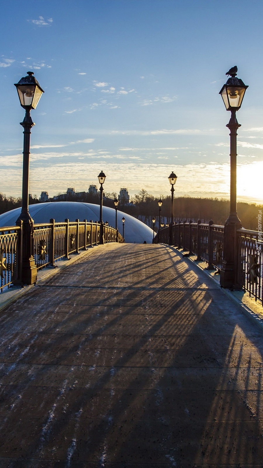 Zimowy wschód słońca nad mostem z latarniami