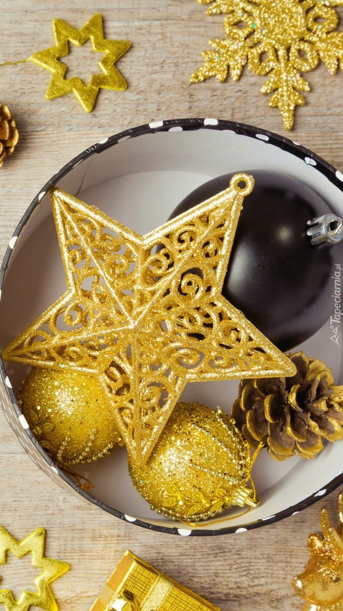 Złote dekoracje na święta z czarną bombką w pudełku