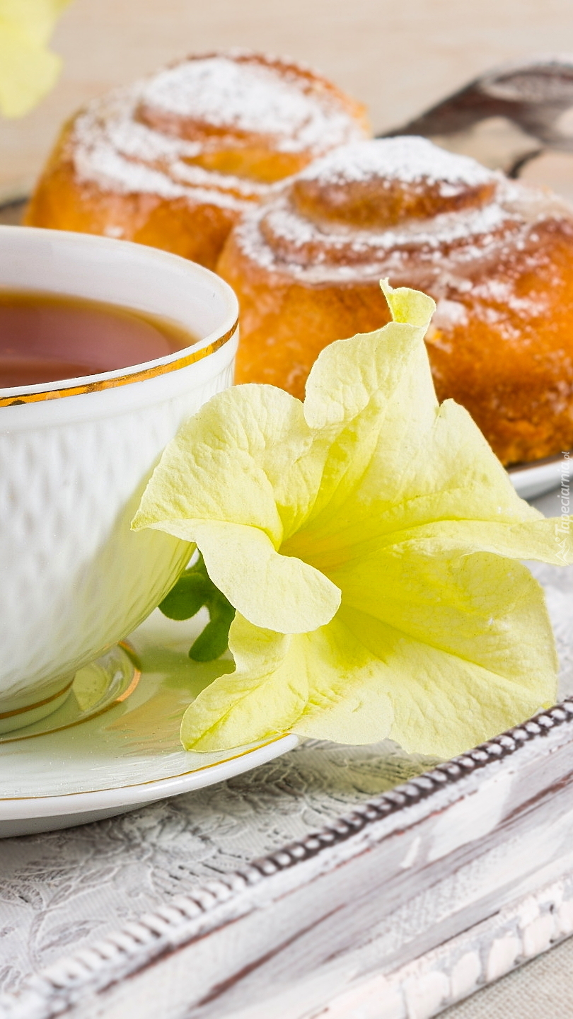 Żółty kwiat przy filiżance herbaty