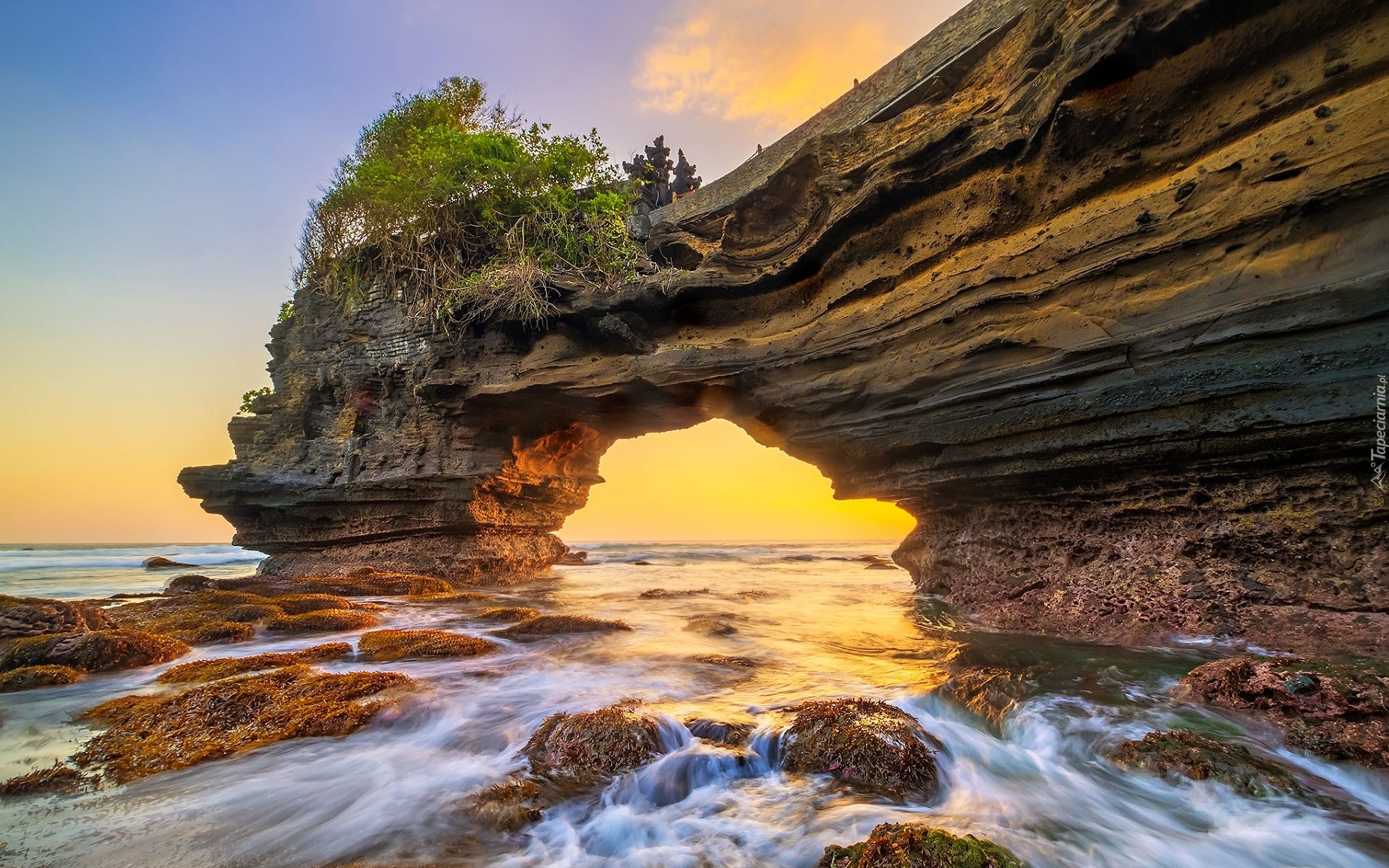 Indonezja, Wyspa Bali, Tanah Lot, Skała, Łuk, Drzewa, Omszałe, Kamienie, Zachód słońca