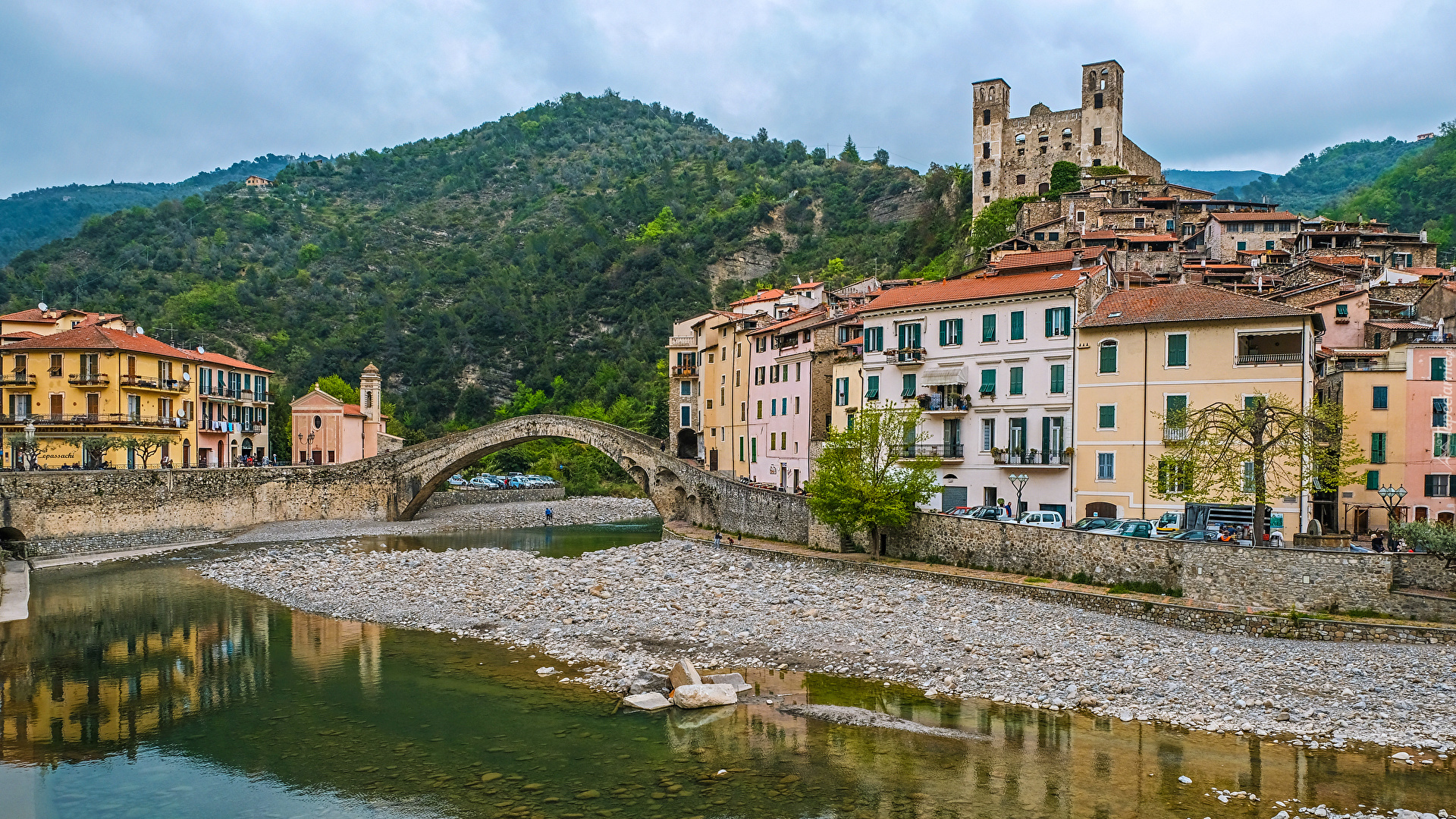 Włochy, Liguria, Miejscowość Dolceacqua, Domy, Rzeka Nervia, Kamienie, Most, Góry, Drzewa