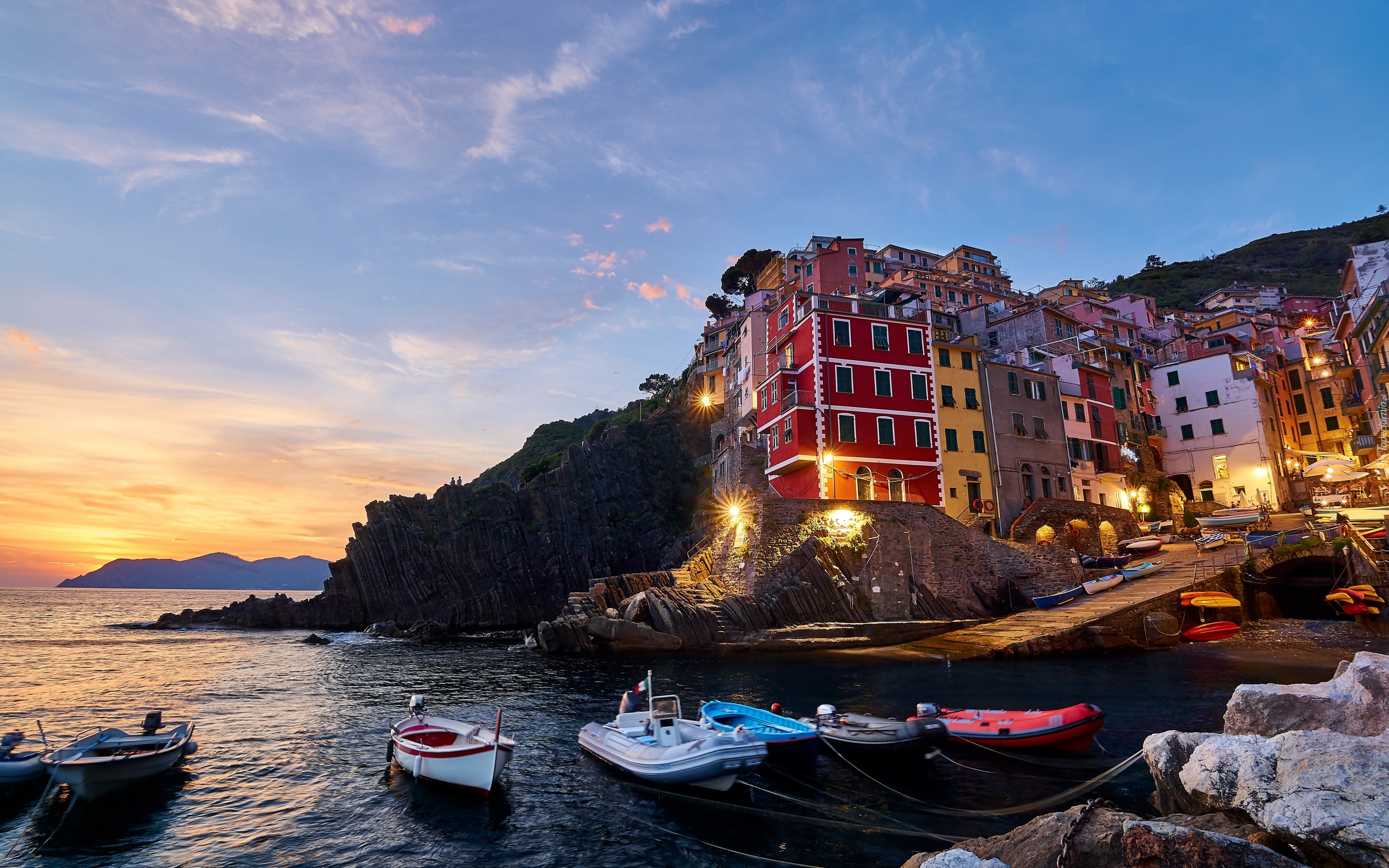 Włochy, Cinque Terre, Miejscowość, Riomaggiore, Domy, Morze, Skały, Zatoka, Łódki, Zachód słońca