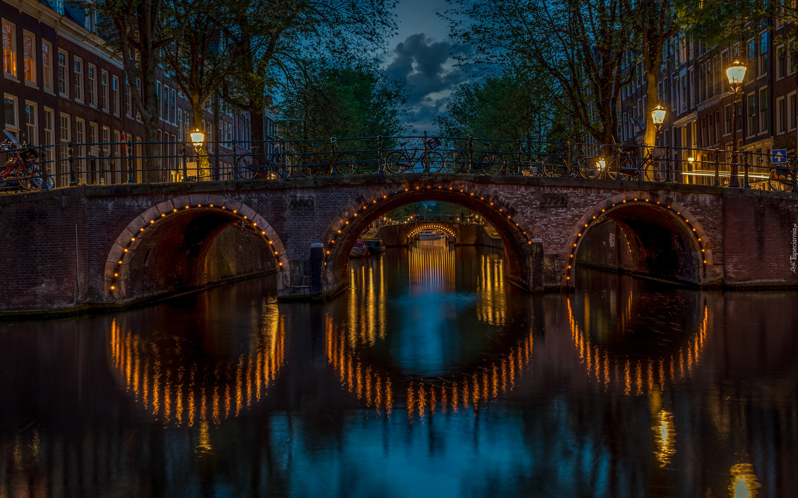 Holandia, Amsterdam, Miasto nocą, Kanał Keizersgracht, Rowery, Most, Oświetlenie, Budynki, Niebo, Chmury, Drzewa, Lampy