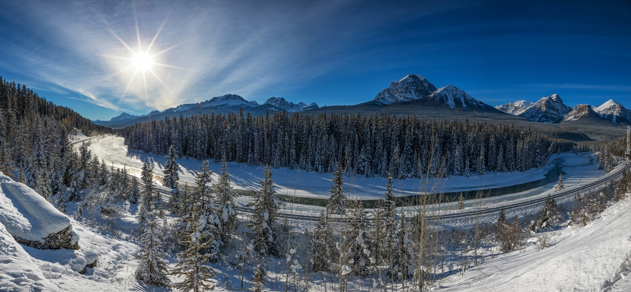 Kanada, Prowincja Alberta, Park Narodowy Banff, Dolina Bow Valley, Góry Skaliste, Drzewa, Rzeka Bow River, Tory kolejowe, Śnieg, Zima, Promienie słońca
