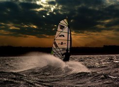 Windsurfing,deska, żagiel , morze,fala Zachód Słońca