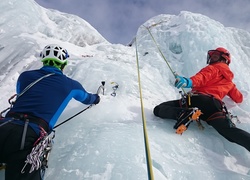 Alpiniści wspinają się na szczyt lodowca