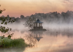 Altanka na zamglonym stawie otoczona drzewami