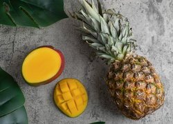 Ananas i mango obok liści