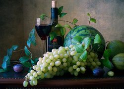 Arbuz i winogrona obok butelki z winem i kieliszkiem