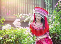 Azjatka w czerwonym tradycyjnym stroju w ogrodzie