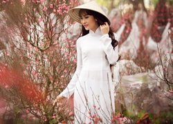 Azjatka w kapeluszu i białej sukni