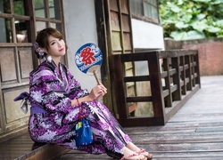 Azjatka w kolorowym kimonie i z wachlarzem w dłoni