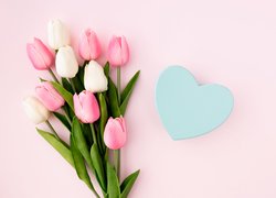 Białe i różowe tulipany obok niebieskiego serca
