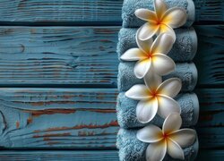 Białe kwiaty plumeri leżące na zwiniętych ręcznikach