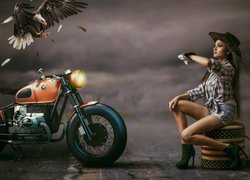 Bielik amerykański nad motocyklem i kobieta w kapeluszu
