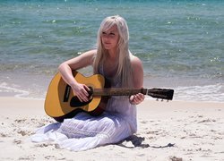 Blondynka w białej sukience z gitarą
