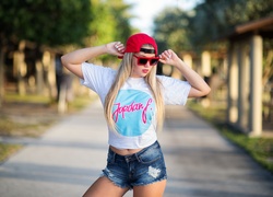 Blondynka w czerwonej czapeczce i okularach przeciwsłonecznych