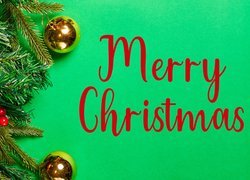 Bombki na gałązkach i napis Merry Christmas na zielonym tle