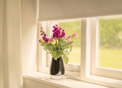 Bukiet kwiatów w wazonie na oknie