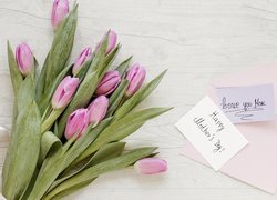 Bukiet różowych tulipanów obok kartki z życzeniami dla mamy