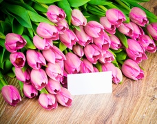 Bukiet różowych tulipanów z karteczką na blacie