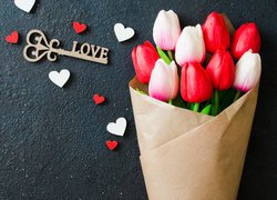 Bukiet tulipanów w papierze obok serduszek i klucza z napisem love