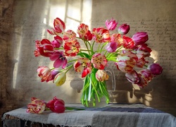 Bukiet tulipanów w wazonie rozświetlony blaskiem światła padającym z okna