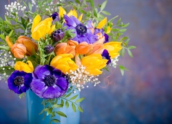 Bukiet z tulipanów i anemonów przybrany gipsówką w wazonie na rozmytym tle