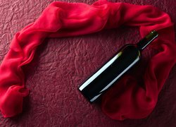 Butelka wina obok czerwonego szalika