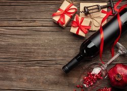 Butelka wina obok prezentów i granatu