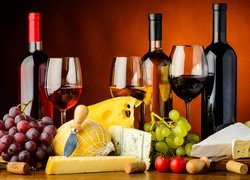 Butelki wina obok serów i winogron