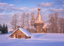 Cerkiew i drewniana szopa w śniegu