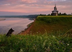Cerkiew na wzgórzu i pies nad jeziorem