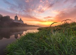 Cerkiew nad zamgloną rzeką o wschodzie słońca