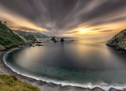 Chmury i zachód słońca nad plażą Playa del Silencio w Asturii