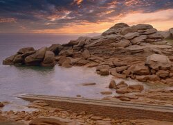 Chmury i zachód słońca nad skałami na brzegu morza