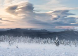 Chmury nad górami i drzewami w śniegu