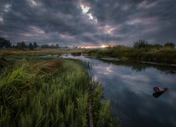 Ciemne chmury nad wiejską rzeką