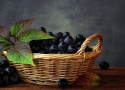 Ciemne winogrona z listkami w koszyku
