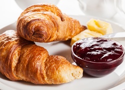 Croissanty i miseczka z powidłami na talerzu