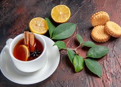 Cytryna i ciasteczka obok herbaty z cynamonem
