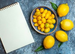 Cytryny i kumkwaty obok notatnika