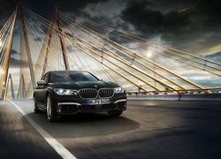 Czarne BMW M760Li xDrive jedzie mostem