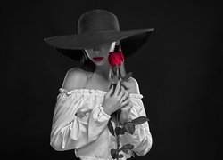 Czarno-biała postać kobiety z czerwoną różą
