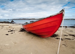 Czerwona łódka zacumowana na plaży
