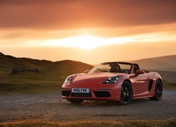 Czerwone Porsche w blasku wschodzącego słońca