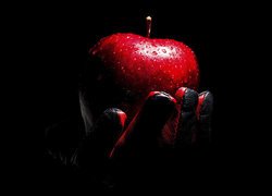 Czerwone zroszone jabłko w dłoni