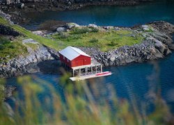 Czerwony dom na skałach nad morzem